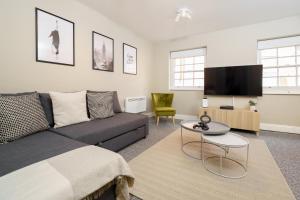 a living room with a couch and a tv at Best Covent Garden/Chinatown/Soho Location in London