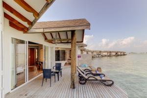 a house on the water with a deck at Cinnamon Dhonveli Maldives in North Male Atoll