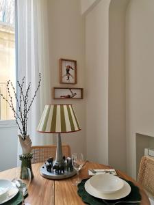 a dining room table with a lamp and plates on it at Coniger 4 Casa vacanze in centro Lecce con Wi-Fi e smart tv in Lecce