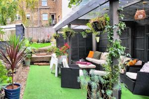 a patio with green grass and furniture and plants at Hidden Gem - One bedroom flat with private garden in Plumstead