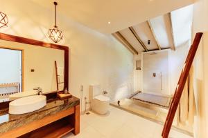 a bathroom with a sink and a toilet and a mirror at Cinnamon Dhonveli Maldives in North Male Atoll