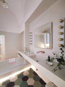 bagno bianco con lavandino e specchio di Coniger 4 Casa vacanze in centro Lecce con Wi-Fi e smart tv a Lecce