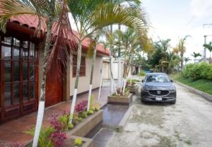 um carro estacionado ao lado de uma casa com palmeiras em Casa de Lujo 5 estrellas ! em Iquitos