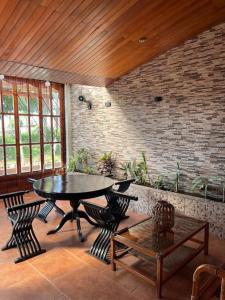 um quarto com uma mesa e cadeiras e uma parede de tijolos em Casa de Lujo 5 estrellas ! em Iquitos