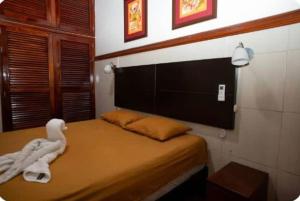 a bedroom with a bed with a towel animal on it at Casa de Lujo 5 estrellas ! in Iquitos