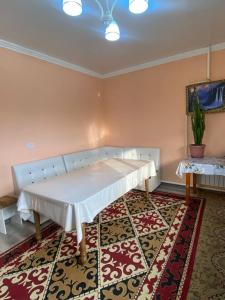 ein Zimmer mit einem Sofa und einem Tisch auf einem Teppich in der Unterkunft Monchok Guest House in Naryn