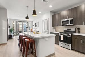 a kitchen with wooden cabinets and a white counter top at Cozysuites PHX RORO Gym, Pool, Pets, Parking! #10 in Phoenix