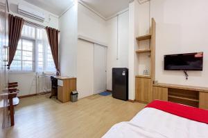 1 dormitorio con 1 cama y TV de pantalla plana en RedDoorz Syariah @ Jl. Candi Kalasan, en Blimbing