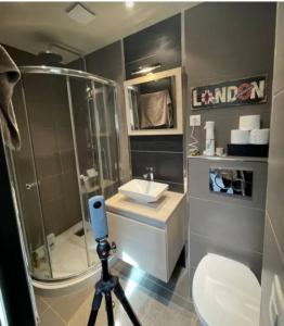 a camera on a tripod in a bathroom with a shower at le prieuré reposant in Notre-Dame de la Mer