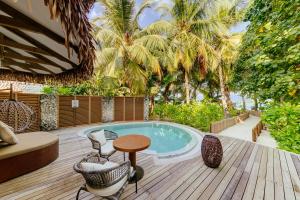 a hot tub on a deck with a table and chairs at Cinnamon Dhonveli Maldives - Complimentary Speedboat Return for 2 pax on 7 nights or more stays valid to 31 Oct 2027 & up to 2 kids stay free in North Male Atoll +153 photos