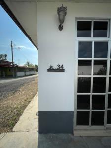 a white building with a window and a sign on it at Tokbah Homestay Alor Setar in Alor Setar