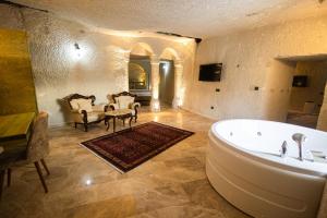 a large bathroom with a tub and a table and chairs at Majestic Cave House in Nevsehir +68 photos