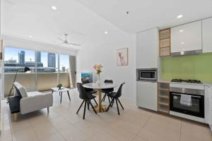 uma cozinha e sala de estar com mesa e cadeiras em Modern 1BR in the Heart of South Brisbane w Wifi Parking em Brisbane