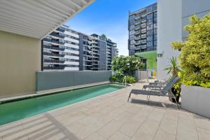 a swimming pool on the roof of a building with buildings at Modern 1BR in the Heart of South Brisbane w Wifi Parking in Brisbane