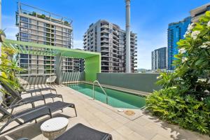 uma varanda com cadeiras e uma piscina num edifício em Modern 1BR in the Heart of South Brisbane w Wifi Parking em Brisbane