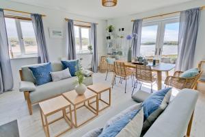 a living room with a couch and a table at Ty Glan Y Mor in Aberffraw