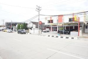 een lege straat in een klein stadje met geparkeerde auto's bij OYO 93695 Guest House Riharti Syariah in Bandar Lampung