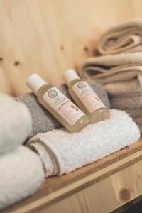 two bottles of shampoo and towels on a shelf at Glamping house Julija - Wellness & View in Ivanjkovci