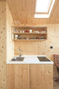 a kitchen with a sink in a wooden wall at Glamping house Julija - Wellness & View in Ivanjkovci