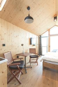 Schlafzimmer mit einem Bett, einem Tisch und Stühlen in der Unterkunft Glamping house Julija - Wellness & View in Ivanjkovci