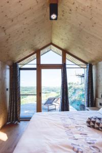 a bedroom with a bed and a large window at Glamping house Julija - Wellness & View in Ivanjkovci