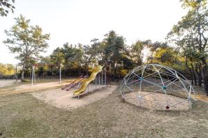 a playground with a slide and a play structure at Tiger Trails Resort in Tāla