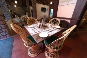 una mesa de madera con sillas de mimbre en un restaurante en Tiger Trails Resort, en Tāla