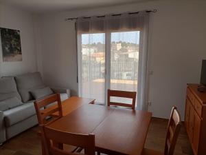 - un salon avec une table, des chaises et un canapé dans l'établissement Apartamentos Rurales Fuente del Peral, à Alobras