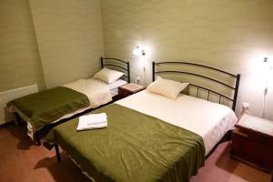 Dos camas en una habitación de hotel con toallas encima. en Apartment Vorontsov, en Tiflis