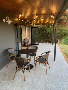 patio con mesa, sillas y TV en The Zen Den, en Walpole