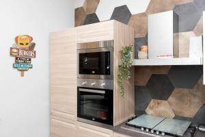 La cuisine est équipée d'un four micro-ondes et d'un mur. dans l'établissement Grazioso Appartamento Aeroporto, à Naples