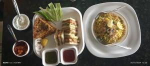 Hotel Ashray في اوجاين: طاولة مع طبقين من الطعام ووعاء من الشوربة