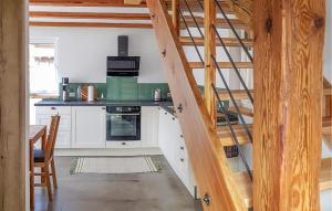 une cuisine avec des placards blancs et un escalier en bois dans l'établissement Cozy Home In Kolbnitz With Wifi, à Unterkolbnitz