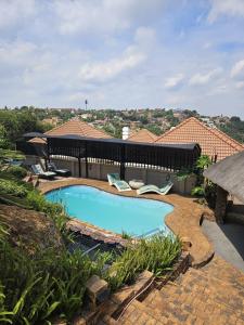 a swimming pool with lounge chairs next to a house at Boutique Stay in Johannesburg