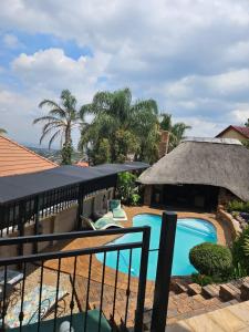 ośrodek z basenem i dachem krytym strzechą w obiekcie Boutique Stay w mieście Johannesburg