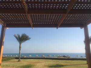 a view of a palm tree and the ocean at Beach Front Chalet (For Families) in Ain Sokhna