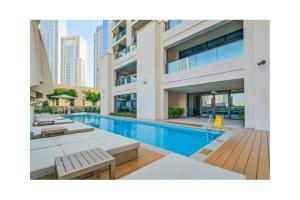 a swimming pool with chaise lounge chairs in a building at Luxury 2-BR Apt with Burj View in Dubai