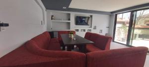 a living room with a red couch and a table at Sharkova House Bansko in Bansko