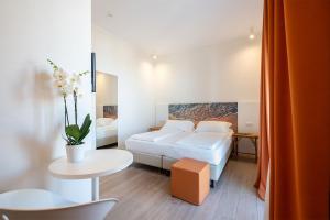 a hotel room with a bed and a table at Hotel Mediterraneo in Sottomarina