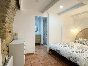 une chambre avec un lit et un mur en pierre dans l'établissement Studio 40m2 au cœur du village, à Cornillon-Confoux