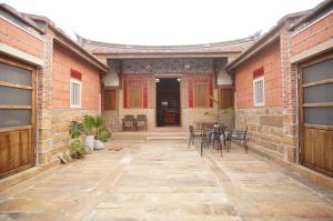 a patio with chairs and tables in a building at Wuzou Guesthouse in Jinsha