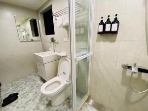 a bathroom with a toilet and a glass shower at Wuzou Guesthouse in Jinsha