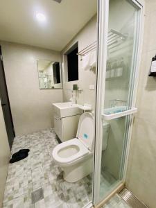 a bathroom with a toilet and a shower at Wuzou Guesthouse in Jinsha