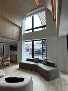 a living room with a couch and a large window at Jace hotel in Bangkok