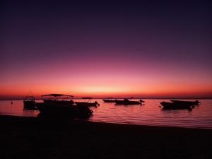 a group of boats on the beach at sunset at Tropical Retreats in Flic-en-Flac