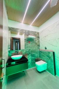 baño verde con lavabo y aseo en HOTEL SIGNATURE INN, en Ambikāpur