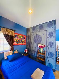a blue bedroom with a bed and a chair at Elephant bungalow at Ya Nui beach in Phuket