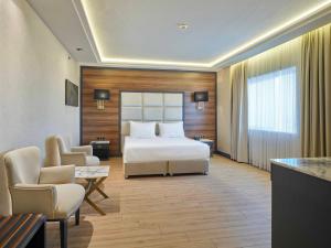 Habitación de hotel con cama, mesa y sillas en Dedeman Sanliurfa, en Sanlıurfa