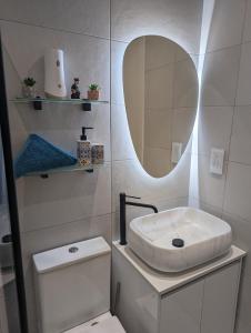 a bathroom with a sink and a toilet and a mirror at Modern & Cosy 1 Bed Maisonette - Close to Salina Bay in St. Paul's Bay