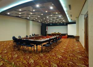 uma grande sala de conferências com uma mesa longa e cadeiras em Five Premiere Hotel em Samarinda